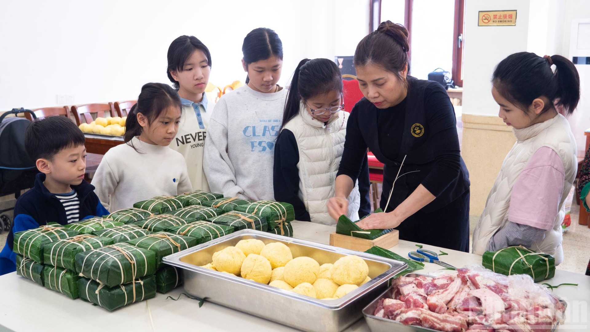 Các cháu thanh thiếu niên, nhi đồng chăm chú theo dõi các khâu gói bánh chưng.