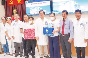 Chuyên gia và y, bác sĩ Bệnh viện Nhi đồng 1 chúc mừng gia đình bệnh nhi P. sau ca mổ thành công.