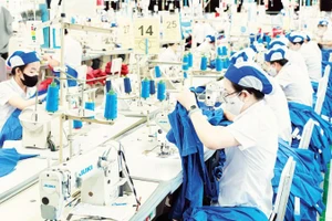 Công nhân làm việc tại một dây chuyền may mặc của Tổng Công ty cổ phần May Việt Tiến.