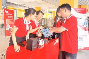 Đại diện Viettel thực hiện thao tác hướng dẫn người dân sử dụng các công cụ chuyển đổi số trong quản lý, kinh doanh ở quy mô hộ gia đình.