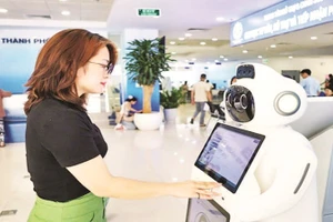 Người dân sử dụng robot AI hỗ trợ, tư vấn thủ tục hành chính tại Trung tâm Phục vụ hành chính công thành phố Hà Nội. (Ảnh LÊ HẢI)