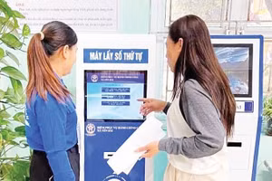 Người dân lấy số thứ tự tự động tại Điểm Phục vụ hành chính công xã Yên Bài (Hà Nội).