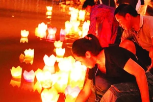Du khách thả hoa đăng trên sông Lục Đầu.