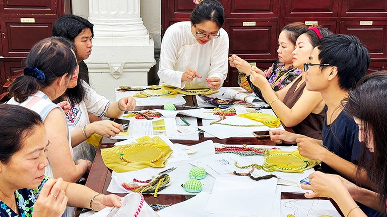 Nghệ sĩ Phạm Ngọc Trâm hướng dẫn các học viên kỹ thuật thêu truyền thống trong chuỗi hoạt động “Sợi chỉ thời gian”. Ảnh: NAM DƯƠNG 132.jpg