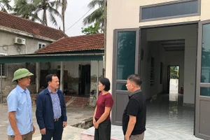 Cán bộ xã Đức Châu (Nghệ An) trao đổi với hộ nghèo được hỗ trợ xây nhà