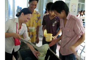 Chị Hồ Phương Thảo phát cháo cho bệnh nhân nghèo.