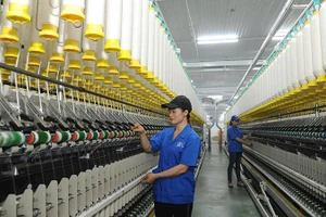Công nhân Công ty TNHH một thành viên Dệt 8-3 vận hành dây chuyền sản xuất sợi.