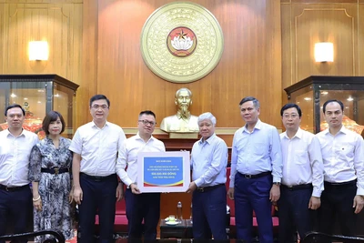 Đồng chí Đỗ Văn Chiến (thứ 4 từ phải sang) tiếp nhận số tiền ủng hộ từ tập thể lãnh đạo, cán bộ, người lao động Báo Nhân Dân.