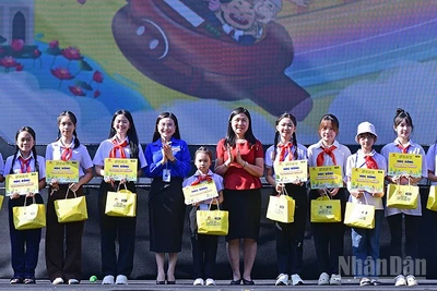 Bí thư Trung ương Đoàn, Chủ tịch Hội đồng Đội Trung ương Nguyễn Phạm Duy Trang (thứ 5 từ trái sang) cùng đại diện Ban tổ chức Ngày hội trao học bổng tặng thiếu nhi vượt khó học tốt.