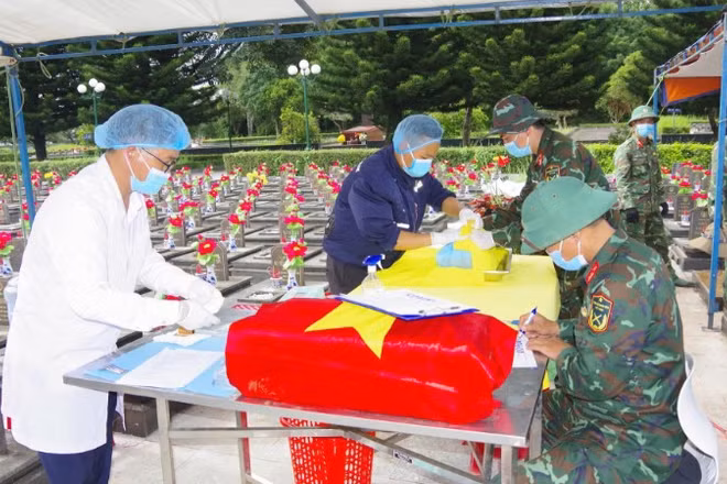 Cán bộ, chiến sĩ Đội lấy mẫu số 2 cẩn trọng thực hiện quy trình khai quật, thu thập mẫu sinh phẩm phục vụ công tác giám định ADN tại Nghĩa trang liệt sĩ tỉnh Gia Lai.