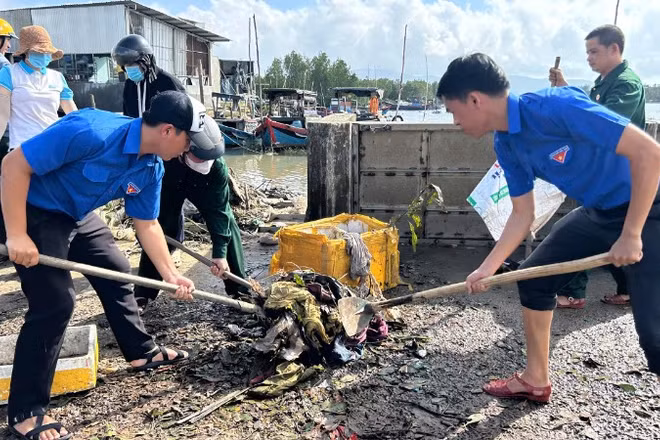 Đoàn viên thanh niên giúp người dân dọn bùn đất sau bão.