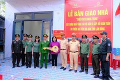 Thủ trưởng Công an tỉnh Lâm Đồng bàn giao nhà mới cho gia đình chị Đỗ Thị Phượng. (Ảnh: TUỆ NHÂN)