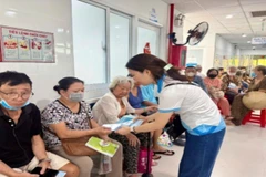 Nhân viên Bảo hiểm Xã hội tư vấn về chính sách khám chữa bệnh Bảo hiểm y tế. (Ảnh: QUÝ HIỀN)