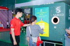 Người tham dự khám phá và tương tác với máy tái chế bao bì 2