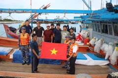 Cán bộ, chiến sĩ đảo Song Tử Tây tặng quà, lương thực, động viên các ngư dân yên tâm vào đảo tránh bão. (Ảnh: CTV HQ)