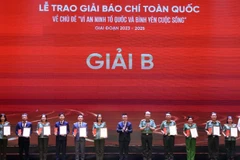 Đồng chí Lê Quốc Minh, Uỷ viên Trung ương Đảng, Phó Trưởng Ban Tuyên giáo và Dân vận Trung ương, Tổng Biên tập Báo Nhân Dân, Chủ tịch Hội Nhà báo Việt Nam và Thượng tướng Trần Quốc Tỏ, Uỷ viên Trung ương Đảng, Thứ trưởng Bộ Công an trao giải Nhì cho các tác giả, đại diện nhóm tác giả. Ảnh: TUẤN ANH/TTXVN