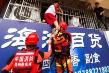 Lực lượng cứu hộ sơ tán người dân khỏi khu vực ngập lụt ở huyện Dong Giang, Tỉnh Quý Châu, Trung Quốc. (Ảnh: THX/TTXVN)