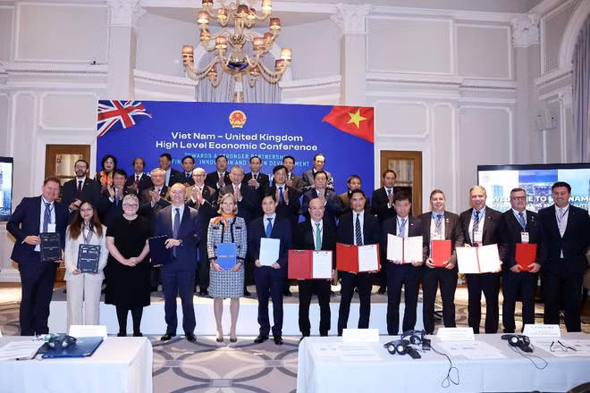 Ông Phạm Minh Tuấn, Phó Tổng giám đốc Tập đoàn FPT (đứng thứ 5 từ phải sang), ông Mark Lloyd Scrivens, Giám đốc FPT Vương quốc Anh, Tập đoàn FPT (đứng thứ 4 từ phải sang) và ông Todd L. Kline, Chủ tịch phụ trách thương mại của CLB Chelsea (đứng thứ 3 từ phải sang) trao thỏa thuận hợp tác trước sự chứng kiến của Tổng Bí thư. Ảnh TTXVN