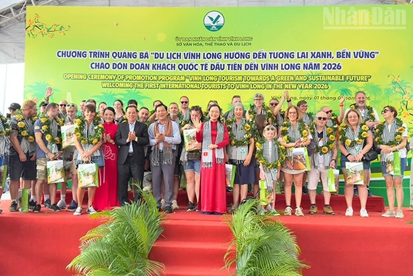 Lãnh đạo tỉnh Vĩnh Long trao quà cho khách quốc tế đầu tiên đến Vĩnh Long. 