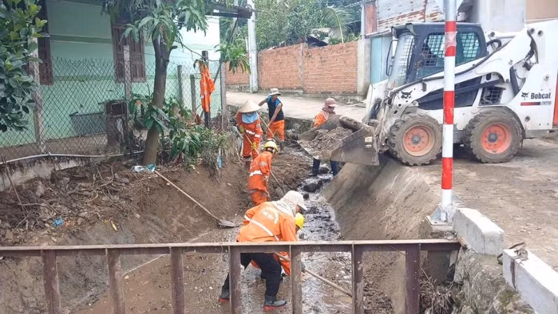 Công nhân bảo dưỡng đường bộ hót dọn cống thực hiện công việc bảo dưỡng thường xuyên.