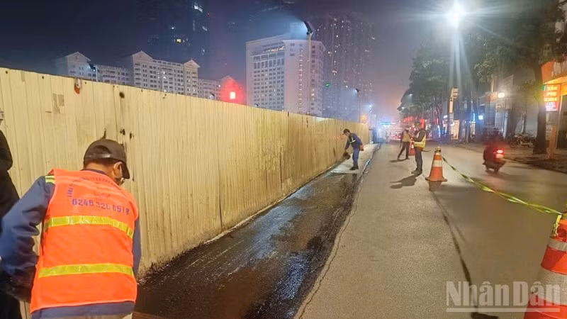 Công nhân thảm lại mặt đường sau khi dỡ bỏ phần quây tôn để trả lại mặt đường cho người tham gia giao thông.