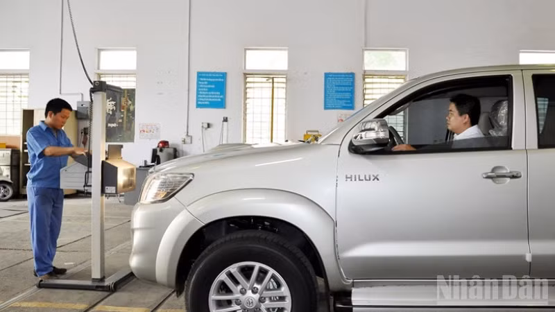 Đăng kiểm viên thực hiện đăng kiểm với một xe ô-tô.