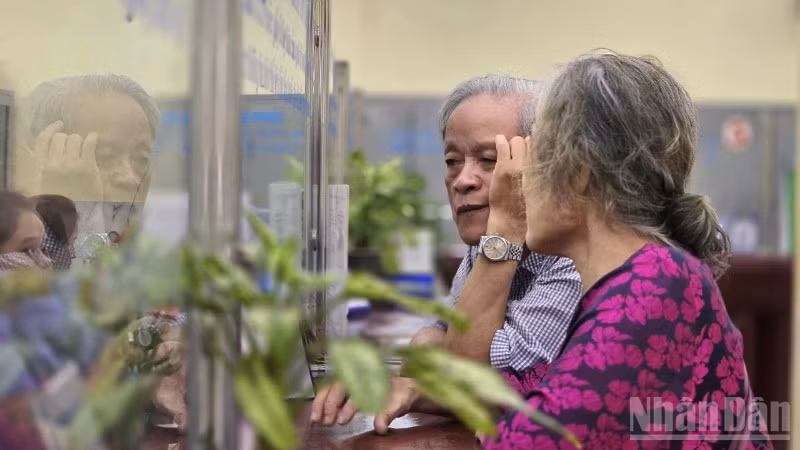 Cụ ông và cụ bà mua vé tàu hỏa tại ga Hà Nội.