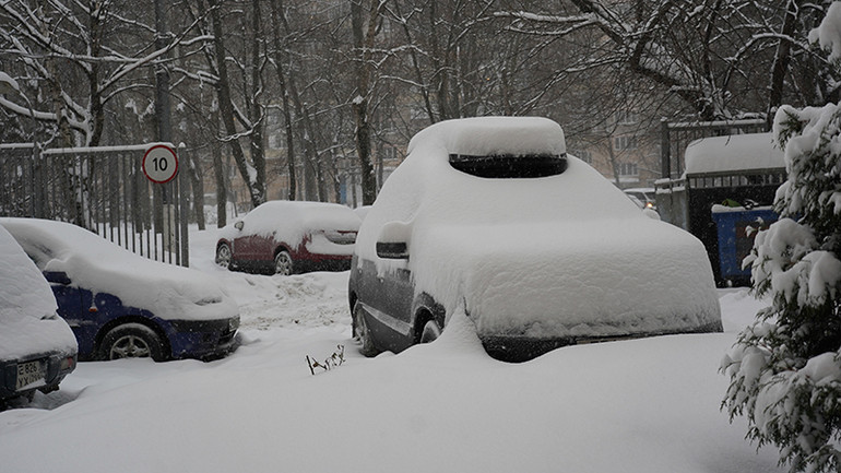 Chỉ trong thời gian ngắn, tuyết rơi đã phủ kín những chiếc ô tô đậu lề đường. (Ảnh: XUÂN HƯNG)