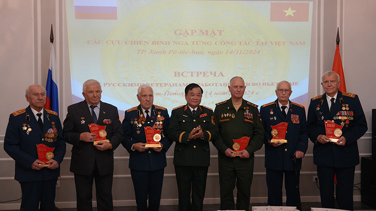 Thượng tướng Hoàng Xuân Chiến trao quà tặng các cựu chiến binh Nga ở Saint Petersburg. (Ảnh: XUÂN HƯNG)