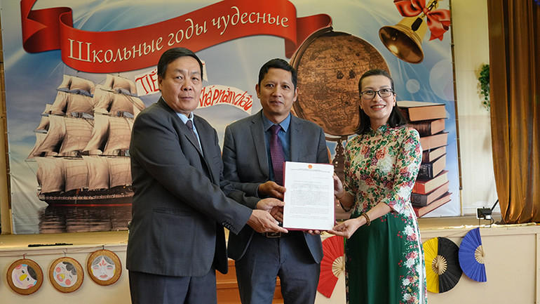 Bà Mai Nguyễn Tuyết Hoa, phụ trách bộ phận giáo dục Đại sứ quán Việt Nam tại Liên bang Nga trao thư chúc mừng của Đại sứ Đặng Minh Khôi cho đại diện Quỹ thúc đẩy hợp tác Nga-Việt "Truyền thống và hữu nghị" và Hội người Việt Nam "Đoàn kết" tại Ulyanovsk. (Ảnh: XUÂN HƯNG)