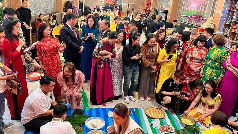 Bà con cộng đồng tham gia thi gói bánh chưng.