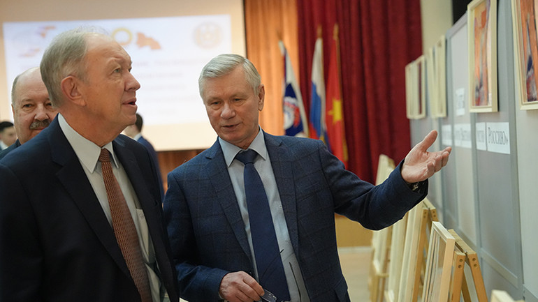 Giáo sư Vladimir Buyanov, Chủ tịch Hội hữu nghị Nga-Việt giới thiệu với cựu Đại sứ Nga tại Việt Nam Andrey Tatarinov những bức tranh vẽ về Việt Nam. (Ảnh: XUÂN HƯNG)