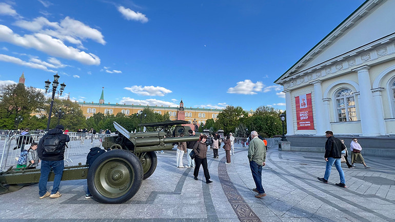 Nhiều du khách tham quan các thiết bị quân sự trưng bày trước lối vào Trung tâm báo chí. (Ảnh: XUÂN HƯNG)