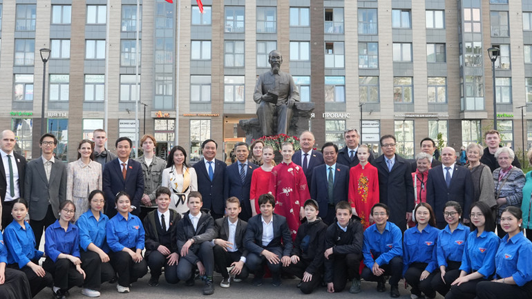 Phó Chủ tịch Quốc hội Lê Minh Hoan chụp ảnh lưu niệm cùng cô, trò trường 488 và sinh viên Việt Nam tại Tượng Đài Chủ tịch Hồ Chí Minh ở Saint Petersburg. (Ảnh: XUÂN HƯNG)