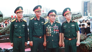 Cựu chiến binh Dương Đình Tấu (thứ 2 từ phải qua) trò chuyện cùng cán bộ, chiến sĩ đội pháo lễ.