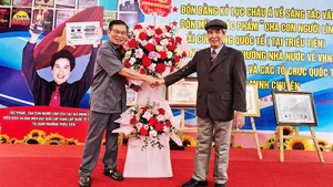 Nhà thơ Lê Tuấn Lộc chúc mừng nhà thơ Minh Chuyên (bên phải) trong ngày vui.