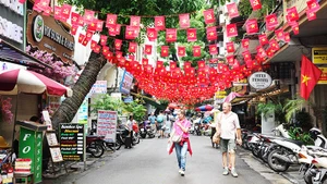 Nhiều tuyến phố Hà Nội rực rỡ sắc cờ.