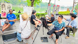 Ký họa chân dung trong không gian phố đi bộ hồ Gươm dịp cuối tuần. Ảnh: HẢI NAM