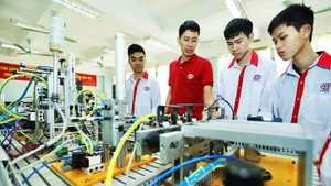 Thầy Cao Hồng Long, (áo sẫm) Trường cao đẳng nghề Công nghệ cao Hà Nội, giới thiệu mô hình tự động hóa cho sinh viên Lớp điện tử công nghiệp K13.