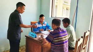 Cán bộ xã Hùng Sơn (TP Đà Nẵng) hướng dẫn người dân chuẩn bị hồ sơ, giấy tờ.