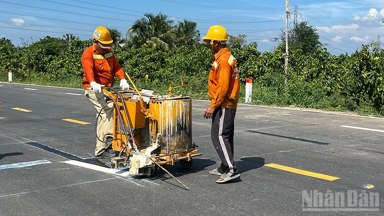 Công nhân vẽ chỉ dẫn giao thông tại đoạn đường thuộc gói thầu số 9. ndo_br_sonkeduong.jpg