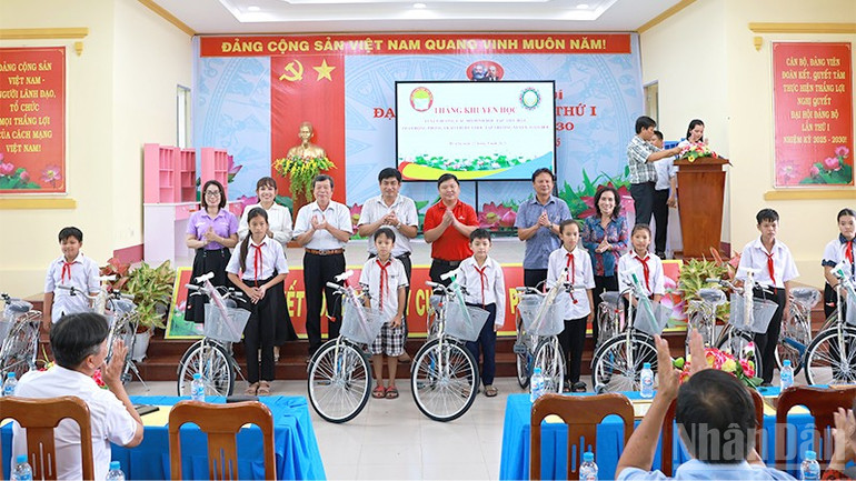 Lãnh đạo xã Mỹ Quý, tỉnh Đồng Tháp và nhà tài trợ trao xe đạp tặng học sinh. ndo_br_myquyxe.jpg
