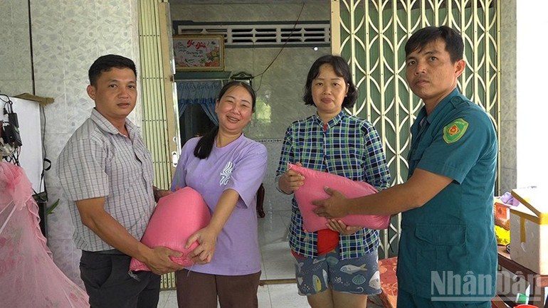 Ban nhân dân khóm Khánh Hòa đến trao gạo hỗ trợ các hộ bị ngập. ndo_br_traogao.jpg