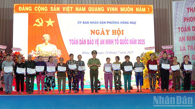 Thứ trưởng Công an Lê Văn Tuyến trao quà tặng người dân phường Hồng Ngự. ndo_br_antq3.jpg