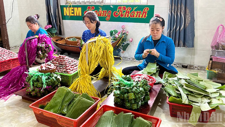 Chị Đặng Thị Ngọc Thùy (ngồi giữa) tham gia công đoạn sản xuất nem. ndo_br_sanxuatnem-2.jpg