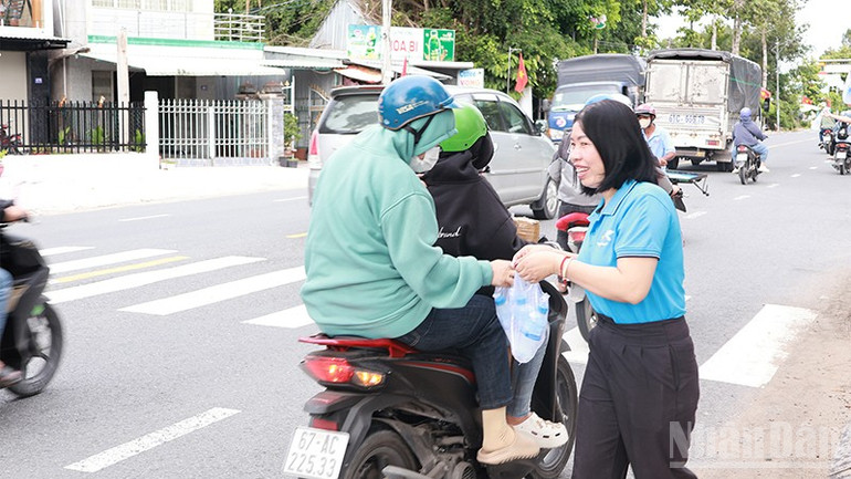 Phát nước suối và khăn lạnh cho người dân về quê nghỉ lễ. ndo_br_dungchan2.jpg