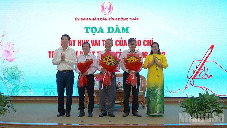 Tặng hoa diễn giả tham dự Tọa đàm. (Ảnh: HỮU NGHĨA) ndo_br_toadam5.jpg