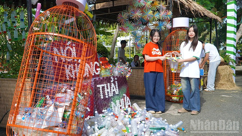 Học sinh mang chai nhựa dùng một lần đổi lấy quà. (Ảnh: HỮU NGHĨA) ndo_br_moitruong5.jpg