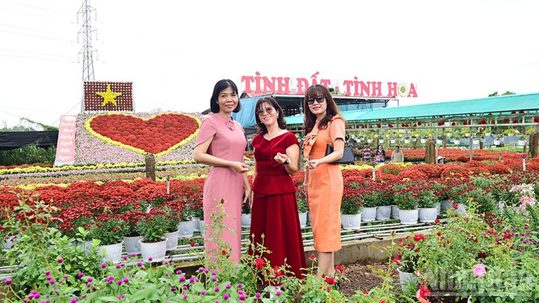 Du khách chụp hình tại tiểu cảnh “Trái tim” hoa khổng lồ có diện tích khoảng 70m2 làm từ 1.600 chậu hoa tươi như dừa cạn, cúc pico và cúc mâm xôi. Lá cờ hoa làm bằng 100 chậu hoa xác pháo màu đỏ và cúc pico màu vàng. Tiểu cảnh đặt tại Tổ hợp tác Sản xuất và cung ứng hoa, kiểng Tân An (phường Sa Đéc).