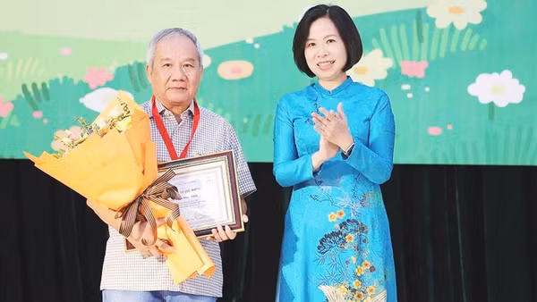 Tổng Giám đốc TTXVN Vũ Việt Trang trao giải Hiệp sĩ Dế Mèn cho nhà văn Trần Đức Tiến. Ảnh: MINH ANH